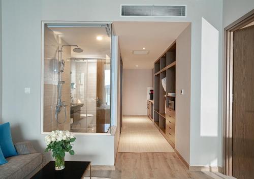 a hallway leading to a bathroom with a walk in shower at Panorama Luxury Beach Front Residences in Nha Trang