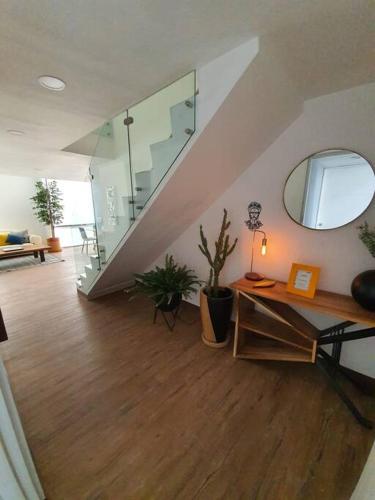 a living room with a staircase and a mirror at Departamento de lujo de 2 pisos en Providencia en Zapopan in Guadalajara