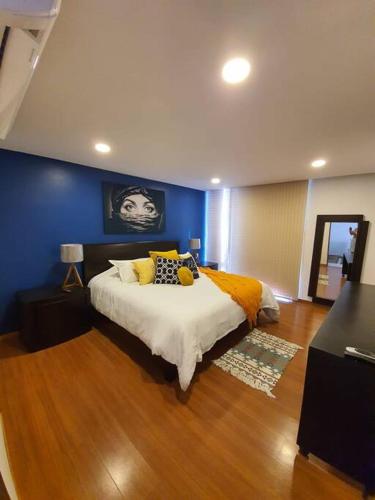 a bedroom with a bed and a blue wall at Departamento de lujo de 2 pisos en Providencia en Zapopan in Guadalajara
