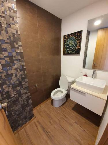 a bathroom with a toilet and a sink at Departamento de lujo de 2 pisos en Providencia en Zapopan in Guadalajara