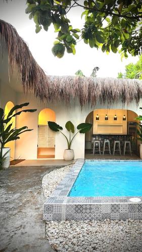 a house with a swimming pool in front of it at BIG WAVES BOUTIQUE HOTEL SIARGAO in General Luna