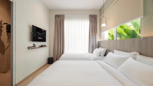 a bedroom with two beds and a window at La Vie Hotel Juru in Simpang Ampat