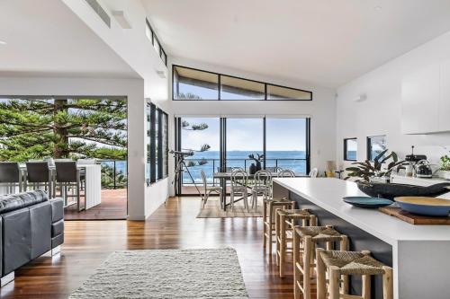 a kitchen and dining room with a view of the ocean at 'rockpool' - Direct Beach Access in Coledale