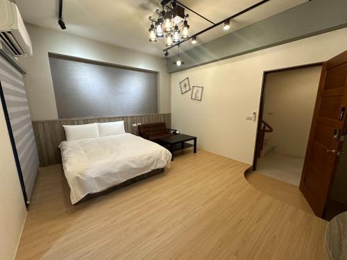 a bedroom with a white bed and a table at 寵物友善-無門禁24小時進出-竹蜻蜓民宿 in Wujie