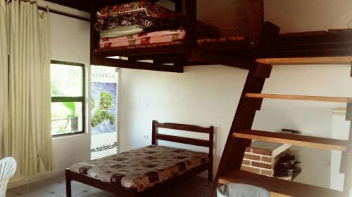 a bedroom with a bunk bed and a staircase with a small bed at Chalé do Saulo in Ilhabela