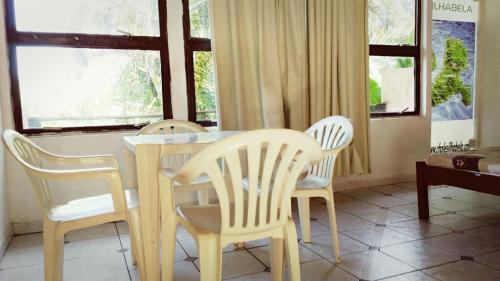 a dining room with a table and four chairs at Chalé do Saulo in Ilhabela
