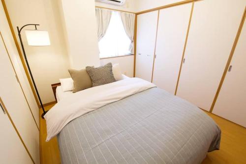 a bedroom with a large bed with a window at AK apartment 2F in Jima