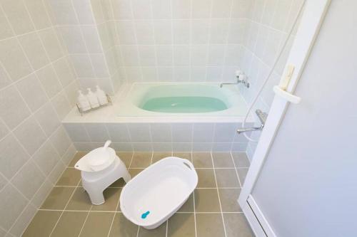 a bathroom with a toilet and a bath tub at AK apartment 2F in Jima