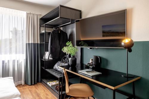 a room with a desk with a monitor on a wall at City Hotel Biel Bienne Free Parking in Biel