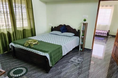 a bedroom with a bed with a pair of gold shoes on it at Tranquil Nest with Private Patio & Swing in Sirsi