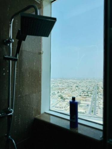 a window in a bathroom with a blue bottle of soap at Spacious 3-Bedroom Apartment near Al Khan Beach in Al Khān