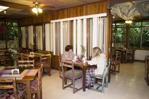 two women sitting at a table in a restaurant at Lands in Love Hotel and Resort in Colonia Palmareña