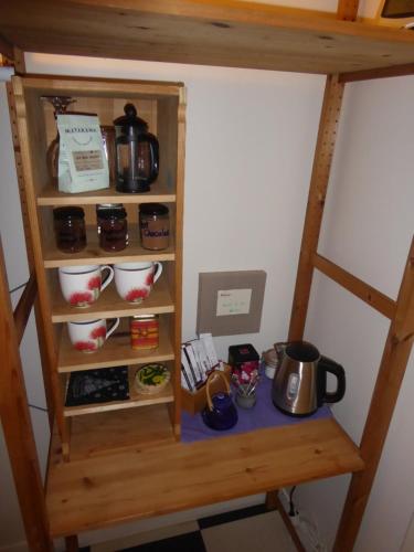 a book shelf with pots and pans on it at Waipapa - The Heart of the Harbour in Diamond Harbour