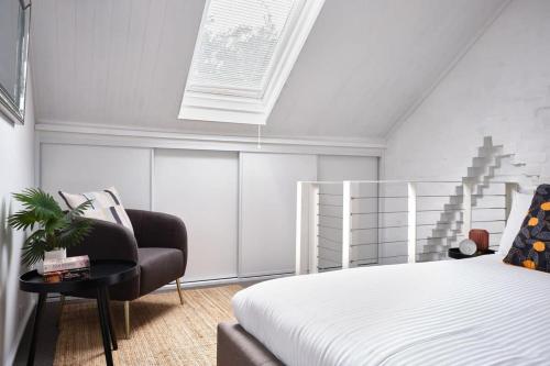 a bedroom with a bed and a chair at Redfern Classic Terrace - Parking and Balcony in Sydney