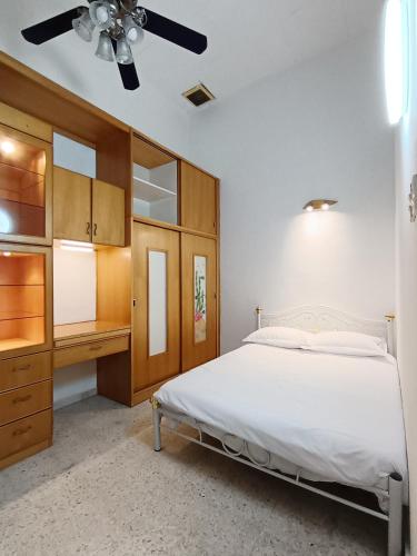 a bedroom with a bed and a dresser and a ceiling fan at 9pax -Taman Bagan Butterworth -Budget Homestay in Butterworth