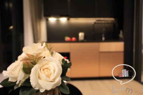 a vase filled with white flowers in a kitchen at The Central Pattaya High Floor, Pattaya City in Pattaya Central