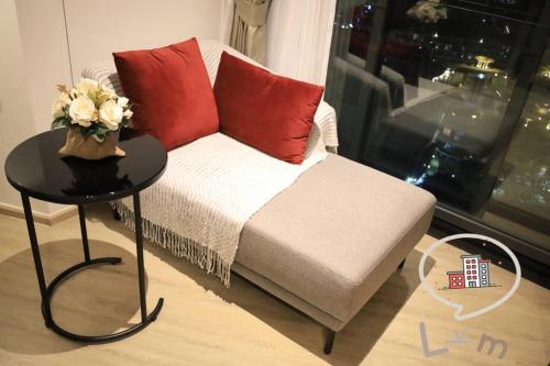 a living room with a couch with red pillows and a table at The Central Pattaya High Floor, Pattaya City in Pattaya Central