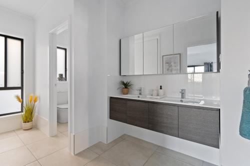 a bathroom with a sink and a mirror at Caves Beach Getaway in Caves Beach