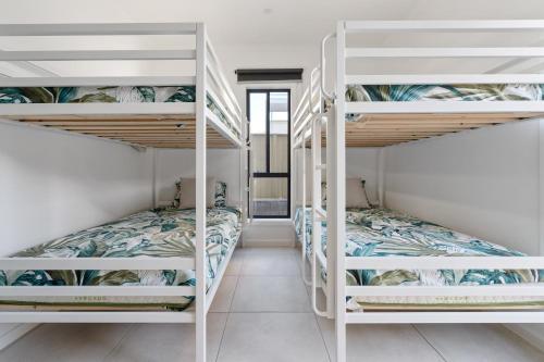 a room with two bunk beds and a hallway at Caves Beach Getaway in Caves Beach