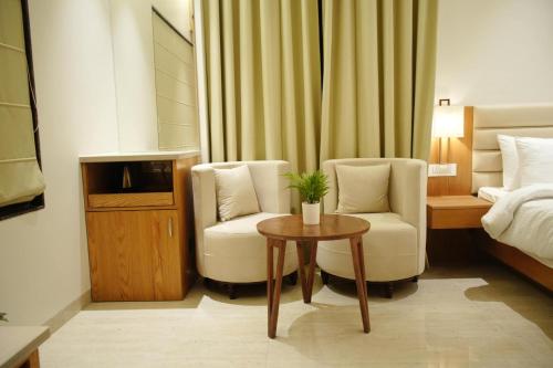 a hotel room with a bed and two chairs and a table at Hotel Rancehok's Mathura in Gokul