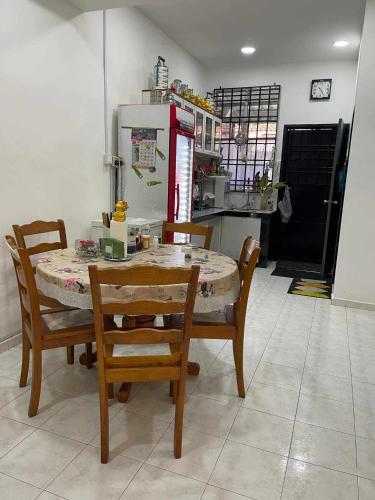 a kitchen with a table and chairs and a refrigerator at Taman Angkasa Nuri in Melaka