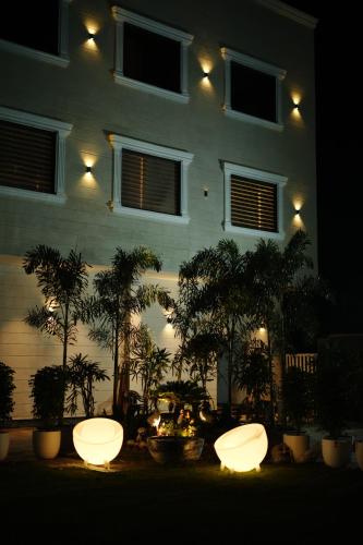 a building lit up at night with trees and lights at Hotel Rancehok's Mathura in Gokul