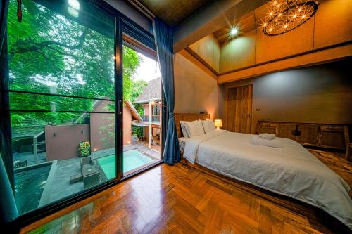 a bedroom with a bed and a large window at 189summer villa曼谷中心Asok&Thong Lor顶级豪宅庄园泳池别墅 in Bangkok