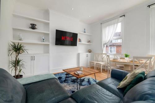 a living room with a couch and a table at Modern Spacious 2 Bedroom Flat near Richmond Park in London