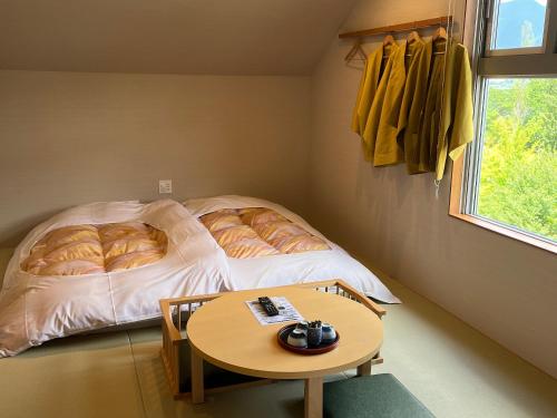 a small room with a bed with a table in it at Royal Hotel Kawaguchiko in Fujikawaguchiko