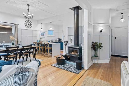 a living room with a fireplace and a dining room at Beautifully Renovated Retreat Modern Comfort with Outdoor Entertaining in Burnie