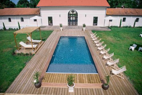 une piscine avec des chaises longues et une maison dans l'établissement Domaine de Bouhémy, à Solférino