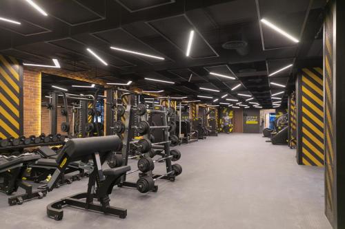 a gym with rows of treadmills and machines at Layali Properties - Boho Oasis 3BR Apt - Convention and Exhibition Center in Riyadh