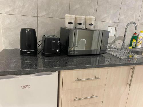 a kitchen counter with a toaster and a microwave at The Manor in Midrand