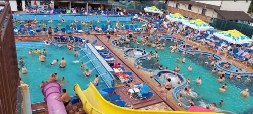 a group of people in a pool at a water park at Sun Garden Glamping Domes in Călimăneşti