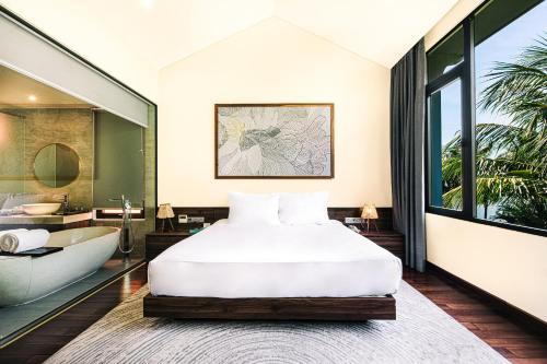 a bedroom with a bed and a bathtub and a bath tub at Hoi An Memories Resort & Spa in Hoi An