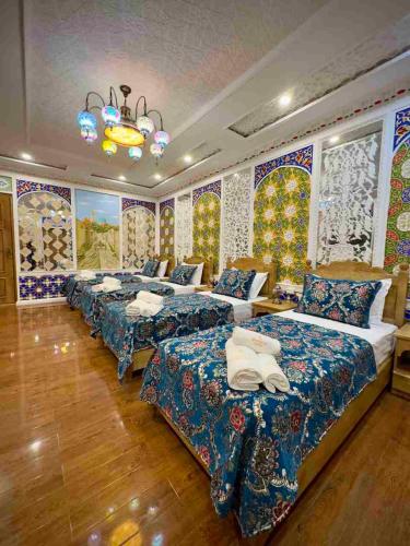 a row of beds in a room with colorful walls at MERITON Boutique in Bukhara