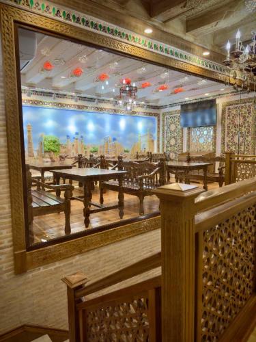 a large mirror on the wall of a restaurant at MERITON Boutique in Bukhara