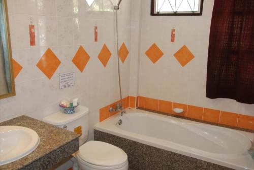 La salle de bains est pourvue d'une baignoire, de toilettes et d'un lavabo. dans l'établissement Phangan Sunset Resort, à Baan Tai