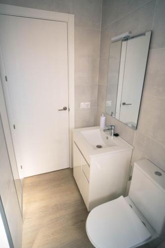 a white bathroom with a toilet and a sink at Frida&Love in Torremolinos