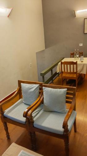 a bench with two pillows in a room with a table at Mountain Club Resort Munnar in Chinnakanal