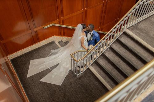 a bride and groom on the stairs at their wedding at Philadelphia Airport Marriott in Philadelphia