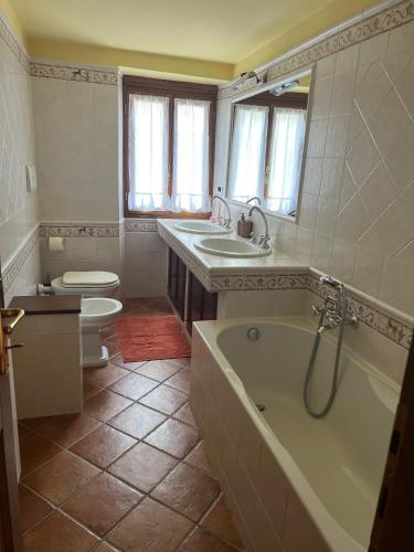 a bathroom with a tub and a sink and a toilet at Casa Sole in Stia