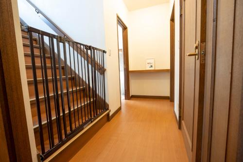 a hallway with a staircase and a stair case at むっくのおうち in Ito