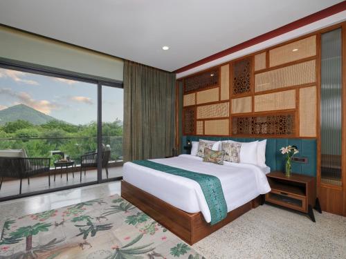 ein Schlafzimmer mit einem Bett und einem Balkon in der Unterkunft amã Stays & Trails Nilaya Amaltaas Villa, Udaipur in Udaipur