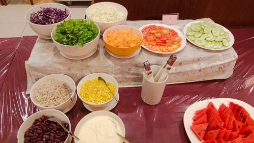 a table topped with bowls of different types of vegetables at Chumphon Gardens Hotel in Chumphon
