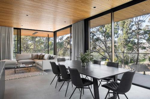 an open living room with a table and chairs at Highstead House in Daylesford