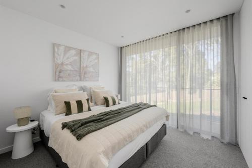 a bedroom with a large bed and a large window at Highstead House in Daylesford