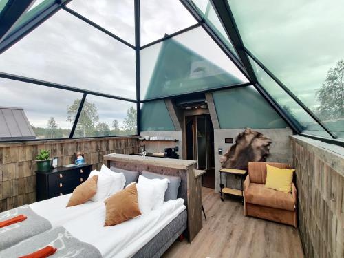 a room with two beds in a glass house at Aurora Pyramid Glass Igloos in Levi