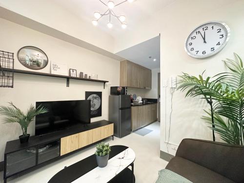 a living room with a large clock on the wall at GemstoneBR in SMDC Fame Residences in Manila