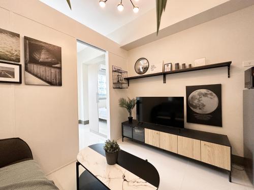 a living room with a television and a table at GemstoneBR in SMDC Fame Residences in Manila